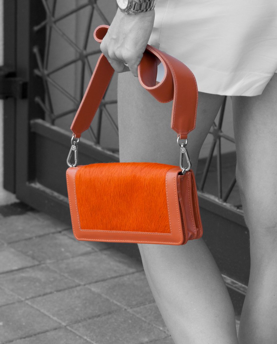 Orange Calf Hair Leather Clutch Bag in woman hands walking away