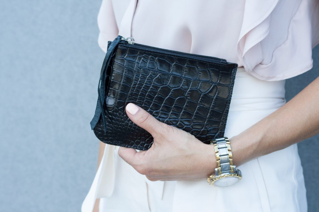Small Flat Pouch in Black Croco Leather in Woman hands.jpeg