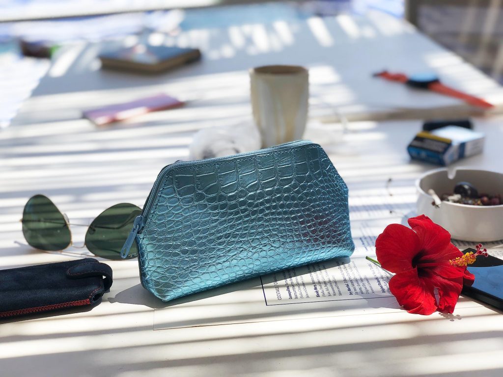 Turquoise Cosmetic Bag on Table with sunglasses 4.jpeg